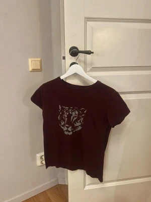 Mörkröd t-shirt Tiger of Sweden - Snygg mörkröd t-shirt från Tiger of Sweden med ett stilrent tigertryck på framsidan och logotypen tryckt på ryggen. Står att det är storlek M men sitter som storlek S 