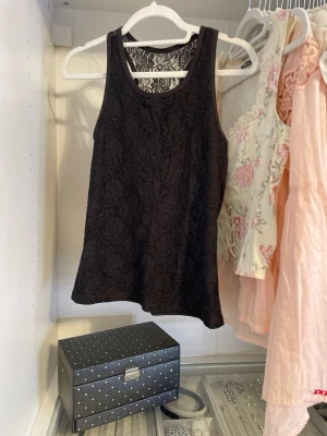 Svart spetslinne - Svart spetslinne med blommönster. Passar XS. 