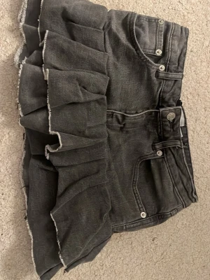 Grå jeanskjol med volang  - Jättesnygg jeanskjol från 157 i storlek S. Den är omsydda från ett par jeans. Jag köpte den som den är men säljer vidare då den är för liten. 