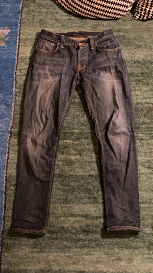 Grim Tim Nudie jeans  - Säljer ett par gamla grim Tim nudie jeans. De ser lite knöglade ut men det är pågrund av att de legat i garderoben länge!