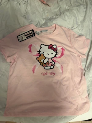 Hello kitty t-shirt - Helt oanvänd tröja med hello kitty motiv. från new yorker, strl M. Var tänkt som julklapp men syrran tappat intresse för HK. Därför är prislappen övertäckt. 