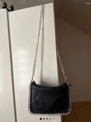 Tiamo väska - En svart tiamo väska, färgen har lossnat lite på vissa delar kedjan men annars så är den fin, säljer därför för lite lägre pris