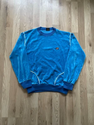 Vintage 90s tröja - Ljusblå vintage tröja med fickor vid midjan. Storlek M men sitter mer som S. Skriv om fler bilder eller mått önskas.