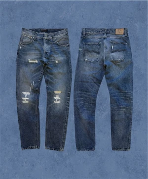 Selvage Steady Eddie ”Fredrik Replica” - Ett par Nudie selvage jeans i en sjukt snygg grå/blå färg och med ofattbart fina slitage som inte går genom tyget! ”Steady Eddie Fredrik Replica” alltså straight fit. Det står 30/32 gå alltid efter måtten. Hör av dig vid frågor! Mått: Ytterbenslängd - 106 cm, Midja - 40 cm, Bensöppning - 17 cm