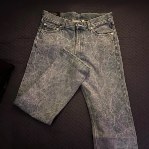 Weekday Klean Regular Straight Jeans - Säljer ett par Weekday Klean Regular Straight Jeans i tvättad ljusblå färg. Klassisk femficksmodell med raka ben och normal passform. Jeansen är tillverkade av bomull och har en snygg vintage-look med slitningar. Perfekt för dig som gillar stilrena och tidlösa jeans.