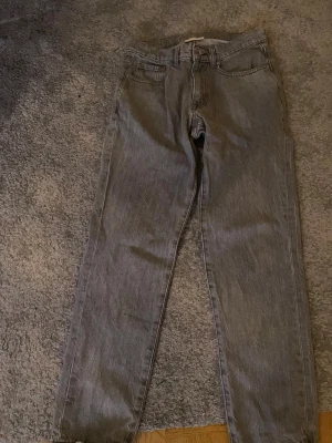Grå jeans från Vailent XS - Säljer ett par grå jeans från Vailent i storlek XS. De har klassisk femficksdesign, raka ben och knappstängning framtill. Jeansen är i en snygg, ljusgrå tvätt och har bälteshällor. Perfekt för dig som gillar stilrena och enkla jeans. Nyskick, har använts max fem gånger.