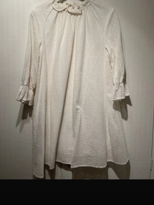 Vit broderad kortklänning Carin Wester - Säljer en söt vit kortklänning från Carin Wester i storlek 38. Klänningen har broderade detaljer, volang vid ärmslut och en rund krage med knyt. Materialet är bomull och klänningen har trekvartsärm. Perfekt för dig som gillar romantisk stil.