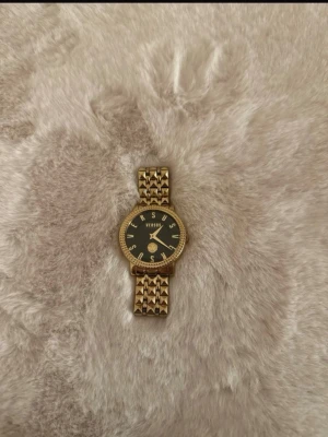 Klocka från Versace versus  -  guldfärgad klocka från Versus Versace med svart urtavla. (Tror jag har kvar boxen) om man skulle vilja ha det