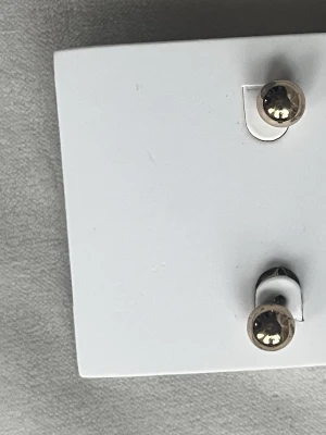 Ingen väst på bildenEtt par runda örhängen i guldfärg  - Ett par runda örhängen i guldfärg 