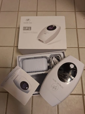 Nordic Skin IPL hårborttagningsapparat - Säljer en vit IPL hårborttagningsapparat från Nordic Skin med digital display och sladd. Kommer i originalförpackning med användarmanual och strömadapter. Perfekt för enkel och smidig hårborttagning hemma.