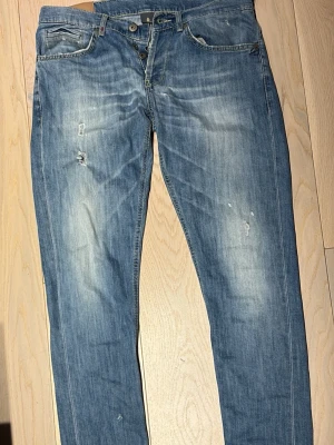 Don dups Jeans - Snygga blå jeans med raka ben och lätt slitna detaljer framtill. Jeansen har klassisk femficksdesign, knäppning med knappar och ljus tvätt. Samt schysst tvätt.  Strl 34