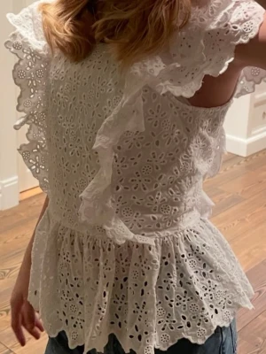 Vit broderad blus med volanger - Söt vit blus ifrån hm, gammal model så passa på! Passar mig i stolk xs