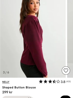 Vinröd blus med knappar från Nelly - Använd en gång men tyvärr lite för liten för mig. Stilren vinröd blus från Nelly med markerad midja och knappar framtill. Blusen har långa puffärmar och en figurnära passform som ger en snygg siluett. Perfekt att matcha med svarta byxor för en trendig look.