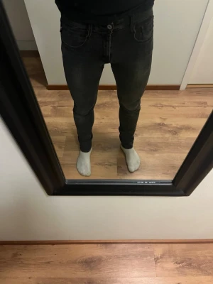 Svarta slim jeans med stretch - Säljer ett par svarta slim fit jeans med snygg tvätt och klassisk femficksdesign. Jeansen har en smal passform och är tillverkade i ett stretchigt material som sitter tajt men bekvämt. Perfekta för dig som gillar en modern och stilren look.