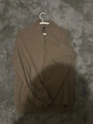 Beige kofta - Stilren beige tröja i mjukt och behagligt material som sitter snyggt och känns skön hela dagen. Den tidlösa färgen gör den lätt att matcha med både byxor och andra plagg! Säljer även den för ett magiskt pris pga brist på användning!