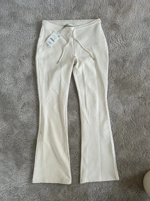 Vita flare mjukisbyxor från Zara - Säljer ett par oanvända vita mjukisbyxor från Zara. Säljer då byxorna inte passade mig. 