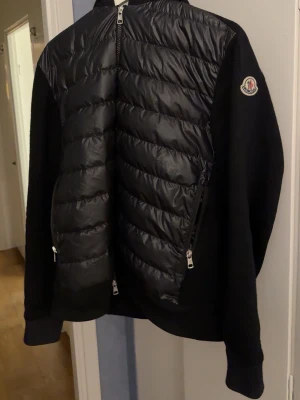 Moncler hybrid jacka storlek XL - Säljer en mycket fin hybrid jacka från moncler med luva, sparsamt använd, inköpt för drygt ett år sedan på NK 