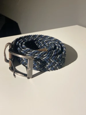Blå/grått bälte  - Snyggt flätat bälte från Massimo Dutti i blått, grått och svart