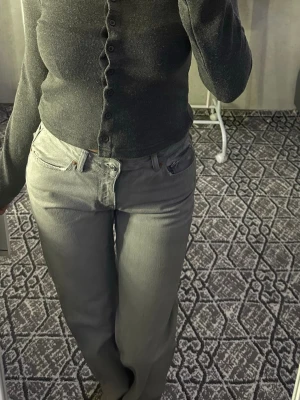 Grå raka jeans med klassisk passform - Snygga grå jeans med raka ben och klassisk femficksmodell. Jeansen har en enkel design utan slitningar och är perfekta för en clean och stilren look. Passar dig som gillar en tidlös vibe och vill ha ett par jeans som funkar till allt.