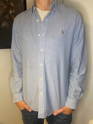 Ljusblå slimfit skjorta från Ralph Lauren - Säljer en fin ljusblå skjorta ifrån Ralph Lauren. Storleken är Medium och slimfit.  Inga defekter på tröjan och den är i fint skick. Modellen är 178 och väger 60kg. Hör av er vid eventuella frågor! 😊