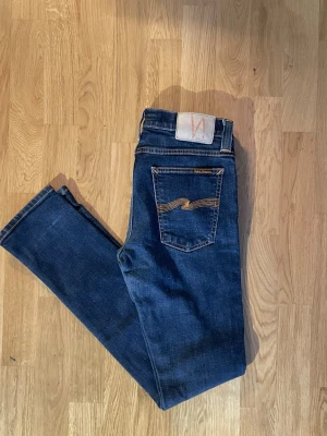 Nudie Jeans Tight Long John Org. Twill Rinsed | W29 L32 | Slim fit - Klassiska Tight Long John från Nudie säljes.  Mått: W29 L32.  Färg: Org. Twill Rinsed (mörkblå/rinsed).  Skick: Bra begagnat skick (se bilder)  Nypris: ~1 500 kr. Hör av dig vid frågor!