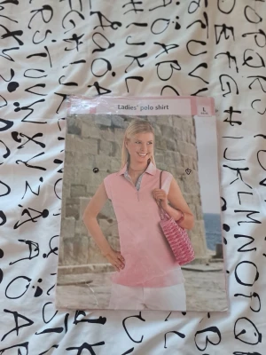 Ny rosa pikétröja stl L (44/46) – Giani Feroti – Oanvänd i förpackning - Säljes:  Helt ny och oanvänd ärmlös pikétröja för dam i en fin ljusrosa färg. Tröjan har klassisk krage med randig dekor på insidan och knappar framtill. Ligger kvar i sin originalförpackning.  Perfekt vår/sommarplagg som passar lika bra på golfbanan som till vardags!  Märke: Giani Feroti Storlek: L (44/46) Färg: Rosa Skick: Ny i förpackning  Övriga frågor skicka gärna meddelande.