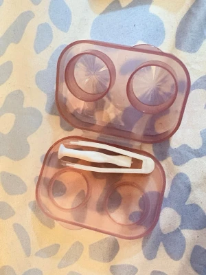 Rosa linsfodral med pincett - Säljer ett genomskinligt rosa linsfodral med två fack för linser och en liten vit pincett för enkel hantering. Perfekt för dig som vill förvara kontaktlinser på ett smidigt och hygieniskt sätt. Liten och lätt att ta med i väskan.