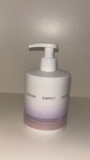 Simply Suede handlotion från Lyko - Simply Suede handlotion från Lyko i en vit pumpflaska med lila och beige toning. Lotionen är lätt och återfuktande med doft av bergamott, varm trä och vit musk. Konsistensen är krämig och färgen är vit. Flaskan rymmer 300 ml. Använt en gång för att känna doften bara.