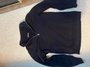Mörkblå half zip sweatshirt från Morris - Snygg mörkblå sweatshirt från primark med half zip-dragkedja framtill. Tröjan har långärmad design och är tillverkad i mjuk bomull. Perfekt för dig som gillar stilrena och bekväma plagg med enkel look.
