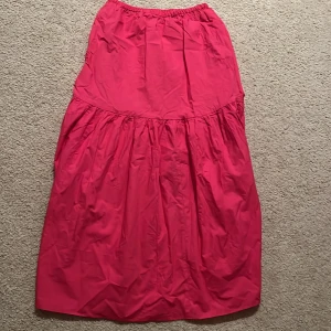 Rosa maxikjol från H&M i S - En snygg och luftig rosa långkjol från H&M med resår i midjan. Kjolen har en voluminös och avslappnad passform som ger extra rörelse. Perfekt för dig som gillar färg och vill sticka ut lite extra.