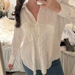 Vit linneskjorta - Vit linneskjorta från Zara i storlek S. Skjortan har klassisk krage, knappstängning framtill och en stor bröstficka. Långärmad och med avslappnad passform🤍