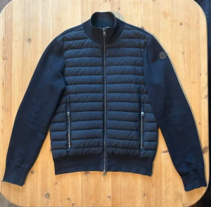 Moncler Cardigan Tricot - Moncler Cardigan Tricot, selger denne utrolig fine og populære moncler cardigan, Kjøpt ny på Ferner Jacobsen, knapt brukt som avbildet helt strøken, tilstand er dermed som avbildet. Størrelse Small, sitter true to size, Sikre deg en populær og fin cardigan til kaldere dager nå🤩, Black Label logo på armen, Nypris 10 000kr +, 2 lommer på hver side av cardigan jakken utenpå, stilrik og fin Moncler Cardigan! 700++ salgsreferanser så her handler du i trygge hender. 