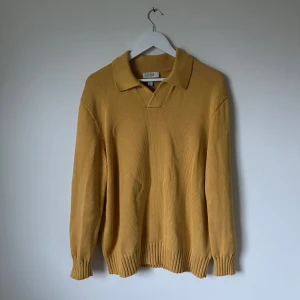 Gul stickad pikétröja från COS - Säljer en chill gul stickad pikétröja från COS i storlek M. Tröjan har klassisk krage, relaxed fit och ribbade muddar vid ärmslut och nederkant. Gjord i 100% bomull för skön känsla. Perfekt för dig som gillar stilren och enkel design. 5I9