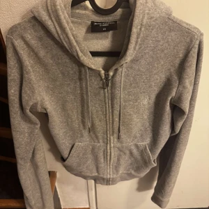 Grå hoodie från Juicy Couture i storlek xs  - Säljer en grå hoodie från Juicy Couture i storlek XS. Den har en dragkedja framtill och en klassisk huva med snören. Den är inte använd mer än ett par gånger. Bara att skriva vid intresse eller frågor💕