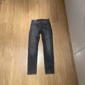 Grå jeans från Pepe Jeans London - Snygga grå jeans från Pepe Jeans London med klassisk femficksdesign och raka ben. Jeansen har en mörkgrå tvätt och slim fit passform, perfekt för dig som gillar stilrena och enkla jeans. Nypris 1100 mitt pris 500.