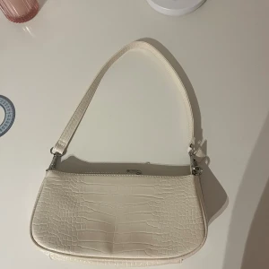 Beige axelväska från Even&Odd - Snygg beige-vit axelväska från Even&Odd med croco-mönstrad yta och silverfärgade detaljer. Väskan har ett avtagbart axelband och dragkedja upptill. Insidan är ljus och har en praktisk innerficka för småsaker. Perfekt storlek för det viktigaste. Skriv till mig så fort du undrar något eller vill ha mått, jag svarar snabbt!💗💗