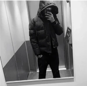 Svart pufferjacka från Canada Goose - Säljer en svart pufferjacka från Canada Goose i storlek M. Jackan har huva, broderad logga på ärmen och klassisk pufferdesign. Perfekt för kalla dagar och har en clean, stilren look som funkar till det mesta.