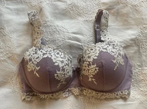 Lila bh med spetsdetaljer - Superfin intimissimi bh med krämfärgad spets och blommigt mönster. Stolek 75D, väldigt fint skick. Köptes för över 600:-