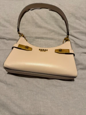 Beige handväska från Guess - Säljer denna väska då jag aldrig använt den! Pris kan diskuteras💕