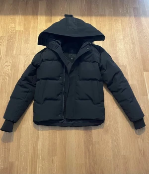 Canada Goose - Black Badge - Nu säljes det en nästan till oanvänd Canada Goose - Black badge. Jackan är i storlek (S) och fläckfri. Vid ytterligare frågor, skriv gärna!
