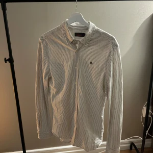 Morris skjorta - Tja! Säljer en riktigt snygg Morris skjorta. Den är i  bra skick 8/10. Skjortan har täcken på användning men har mycket kvar. Den är i färgen vit och brun. Märket är mörkbrunt. Storlek M men skulle säga att den passar bättre S. Den är perfekt till alla tillfällen! Nypris runt 1800 kr Hör av dig vid funderingar🙌