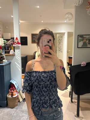 Blå blommig sommar topp - Säljer en söt blommig sommar tröja, kan ha som off shoulder och inte. 