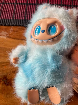Pop Mart The Monsters Plush Figures - Säljer tre Pop Mart The Monsters samlarfigurer i plysch, i färgerna blå, rosa och peach. Figurerna har unika ansikten med stora ögon och leenden, och är i mycket fint skick utan synligt slitage. Perfekt för samlare eller som dekorativa gosedjur. Det går också att sänka priset om det blir för dyrt med 500kr