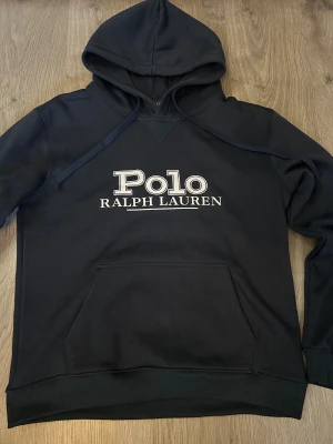 Ralph Lauren hoodie  - Mörkblå hoodie från Polo Ralph Lauren med stor vit logga på bröstet. Den passar storlek M fast det står L 