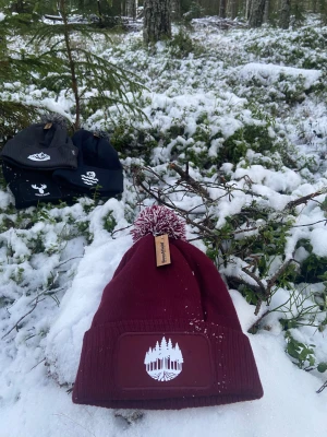 Mössa med skog - En vinröd mössa med vit tryck på, trycket är en skog. Helt oanvänd då vi själv har tryckt den. Mössan samt trycket är av bra kvalitet.