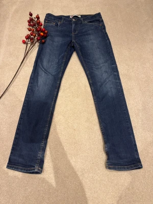 Levi's 512 Slim Taper jeans blå - Snygga Levi's 512 Slim Taper jeans i klassisk blå färg. Jeansen har smal passform Jeansen har fem fickor, gul kontrastsöm och den ikoniska röda Levi's-taggen på bakfickan. Perfekt för dig som gillar en modern och stilren look. Matchar bra med nästa alla tröjor och T-shirtar. Jeansen är knappt använda och köptes för 512kr. Storlek 164 i barn.