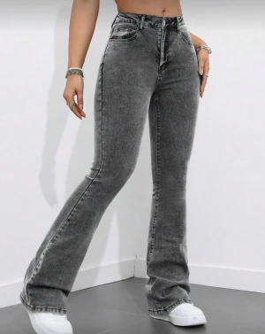 Grå bootcut jeans med hög midja - Snygga grå jeans med bootcut passform och hög midja. Jeansen har klassisk femficksdesign, dragkedja och knapp framtill. Materialet är jeans med en tvättad look som ger en cool vibe. Perfekt för dig som gillar en trendig och avslappnad stil.