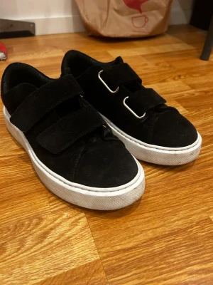 sneakers Sneaky Steve - Svarta sneakers från Sneaky Steve med breda kardborreband och vita platta sulor. Knappt använda och är i fint skick!