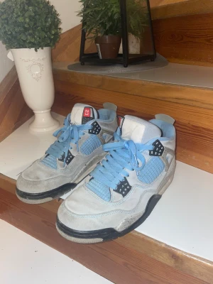 Nike Air Jordan 4 University Blue - Säljer ett par Nike Air Jordan 4 University Blue. Skorna har sätt bättre dagar men dem är inte allt för slitna, därav priset, kan kommer överens om något vid intresse! Frågor eller annat så är det bara att skriva! Har även lite andra kläder så bara skriva o fråga. Storlek 42-43 box finns med