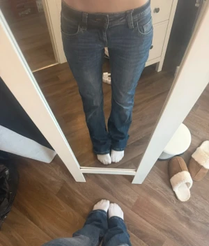 Blå bootcut jeans från Divided, Str 34 - Säljer ett par blå jeans från Divided i storlek 34. Modellen har bootcut-ben och snygga ficklock och knappdetaljer bak.              Super fina💕